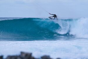 A kitesurfer on the lip of a wave