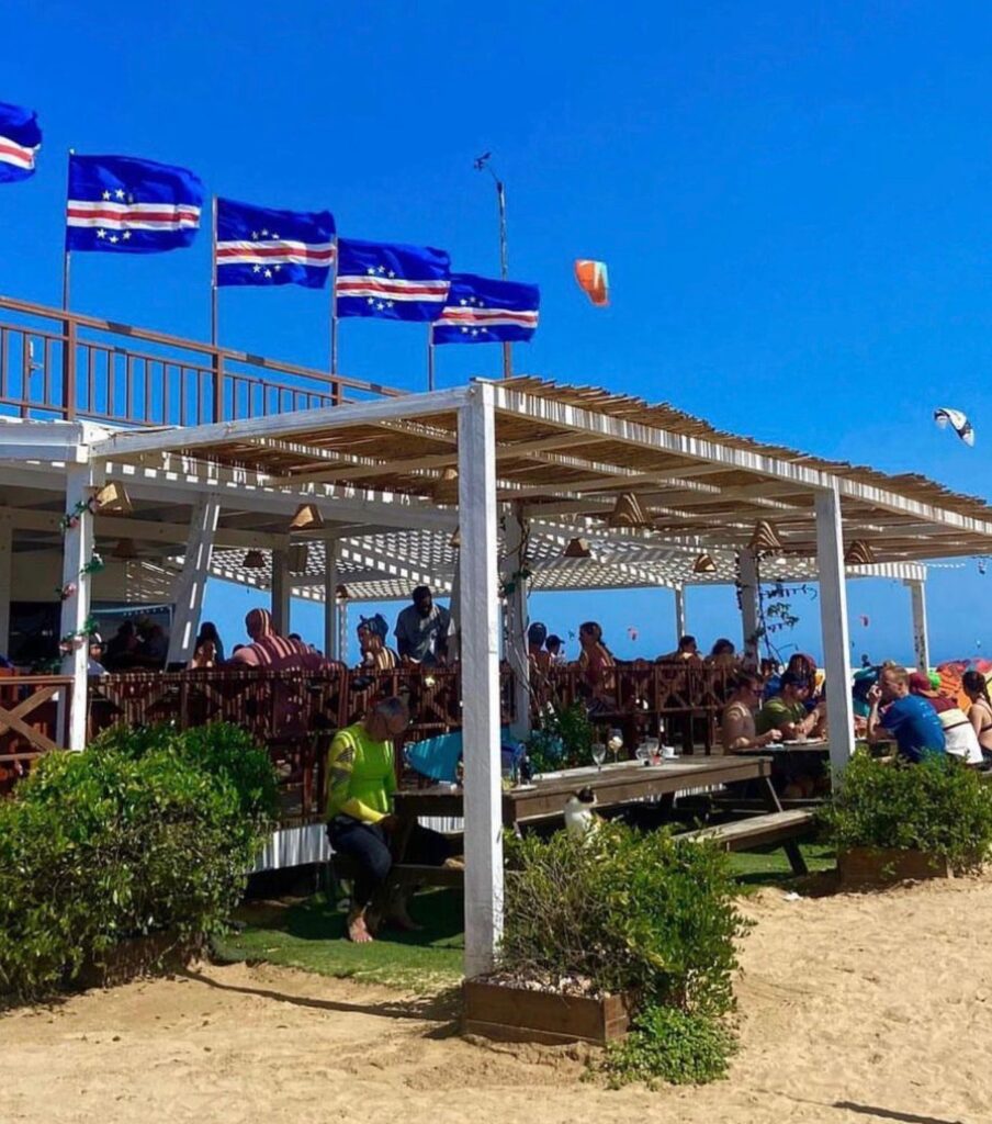 Guests at the restaurant tables, under the pergola and the Cape Verde flags